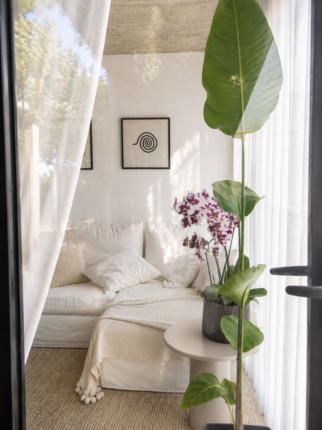Rincón de lectura junto al ventanal, con sillón claro y una planta de hoja grande