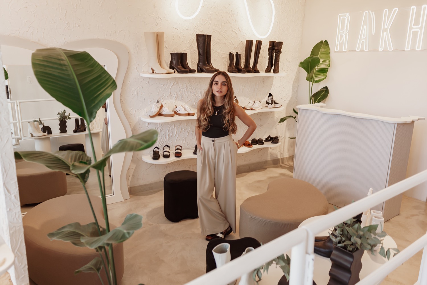 Vista del local Rakhi con plantas interiores y estanterías curvas iluminadas