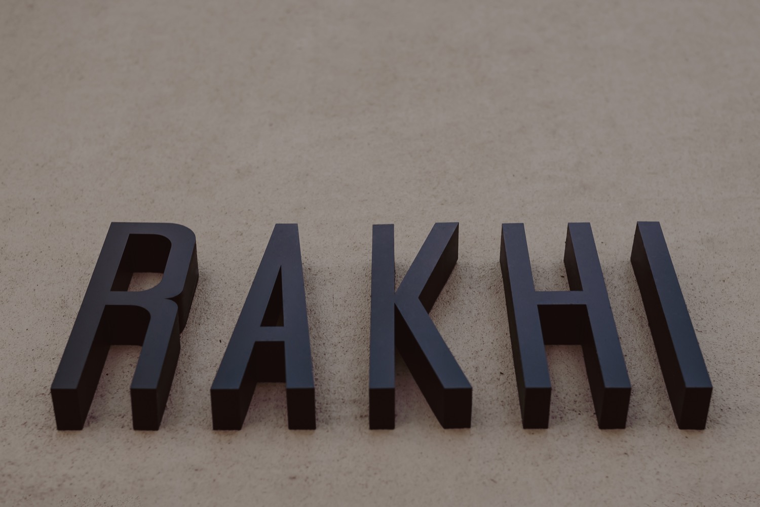 Las letras del logo de Rakhi montadas en relieve sobre el muro del local