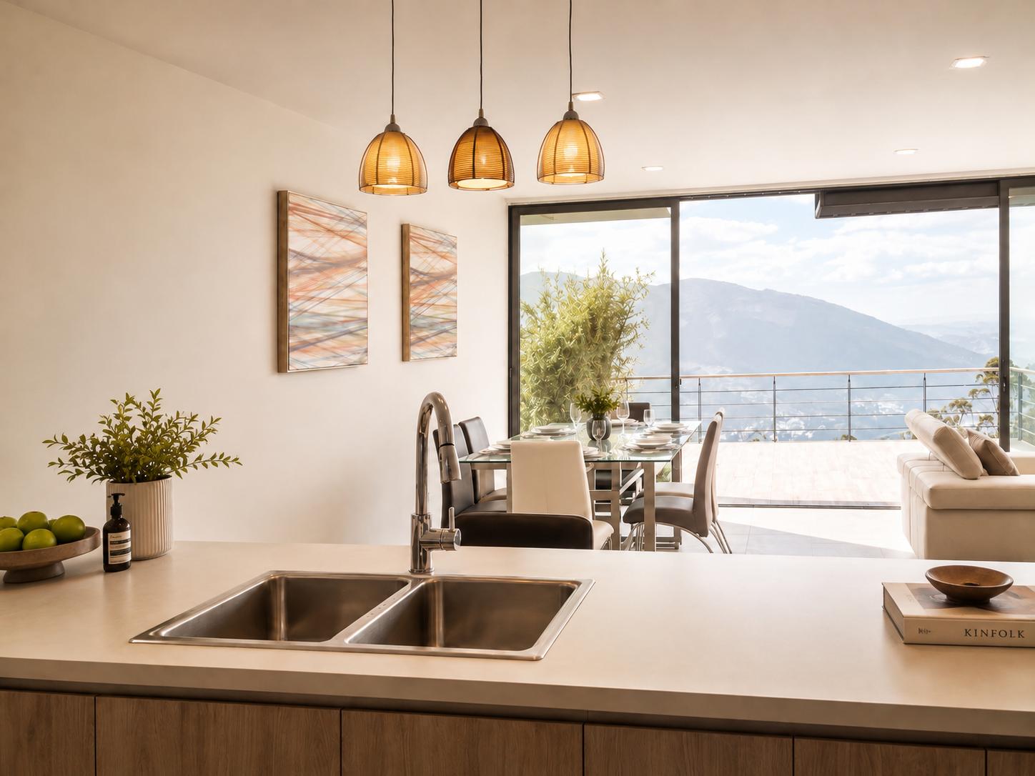 Cocina abierta de la casa Sevillana con isla, colgantes de vidrio y vista al valle