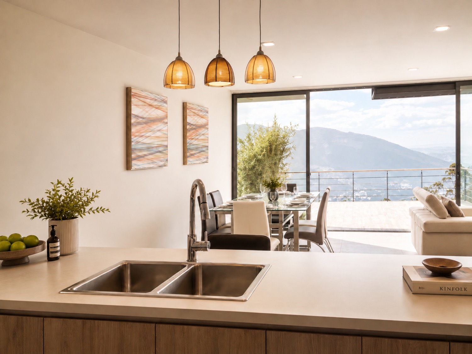 Cocina abierta de la casa Sevillana con isla, colgantes de vidrio y vista al valle