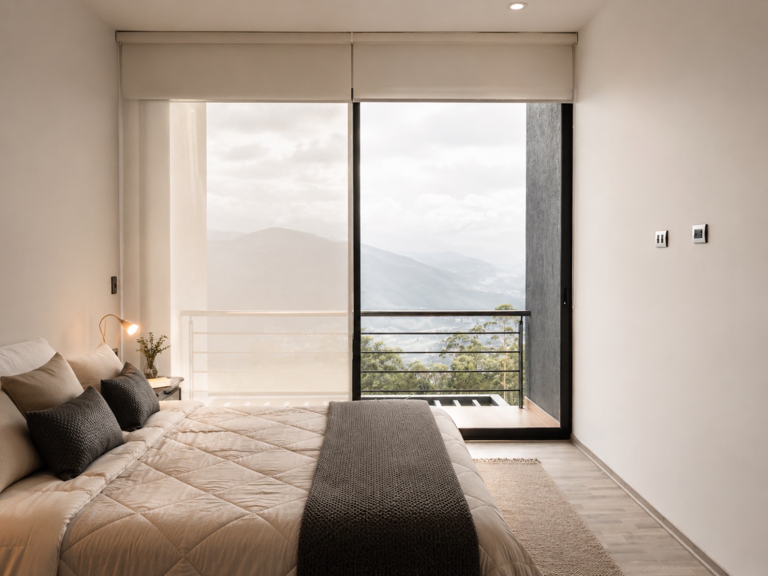 Dormitorio en suite de la casa Sevillana con ventanal a la montaña y ropa de cama clara