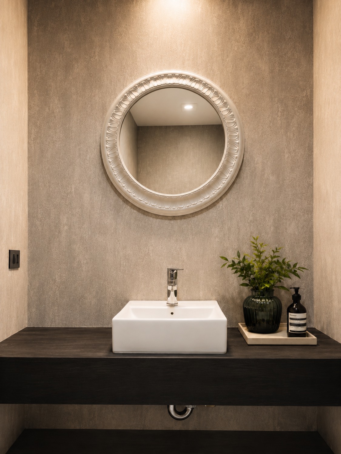 Baño de la casa Sevillana con mesada de piedra y espejo redondo retroiluminado